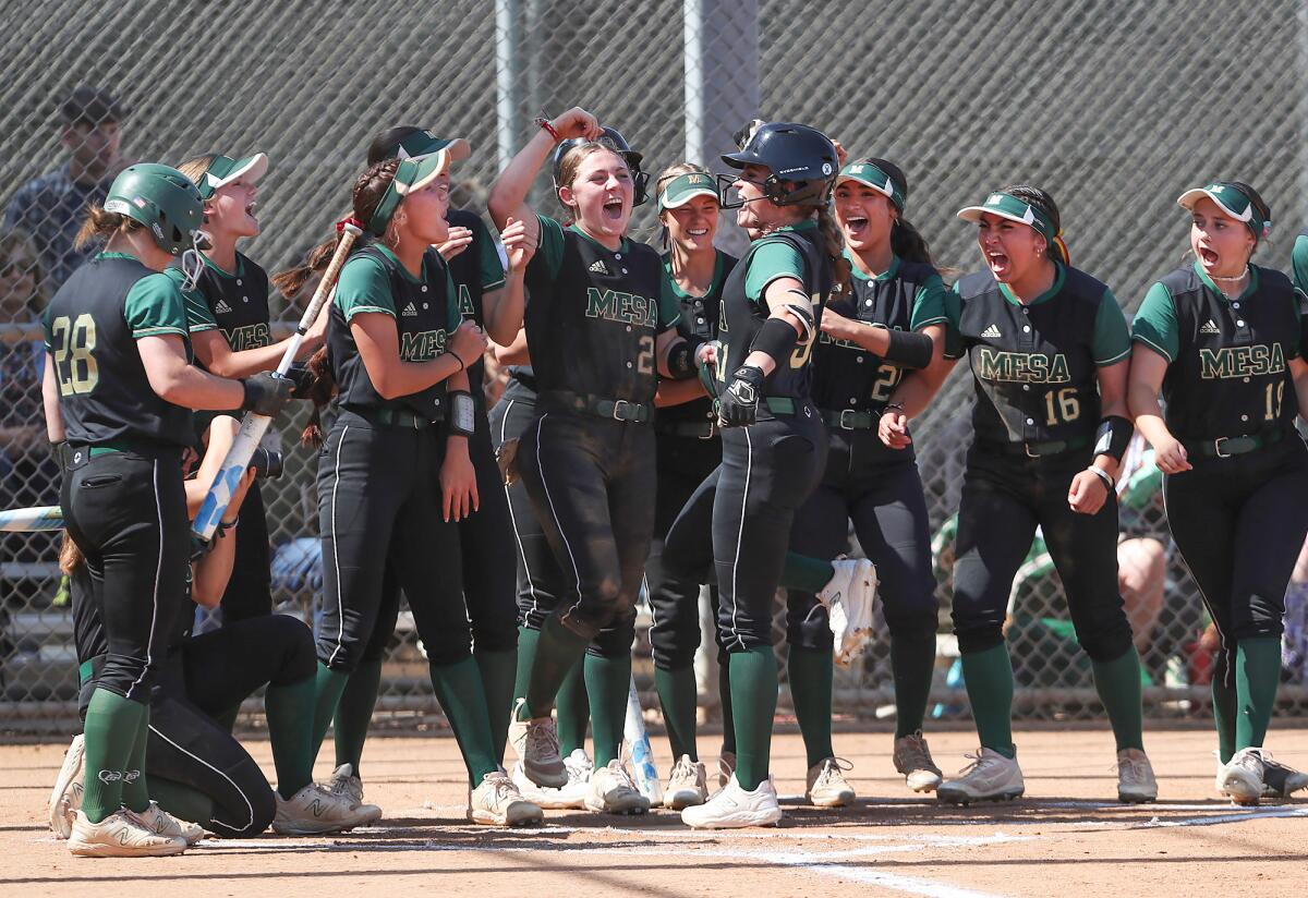 Murrieta Mesa's Paige Bambarger (51) is mobbed by teammates after hitting a home run against Huntington Beach on Thursday.