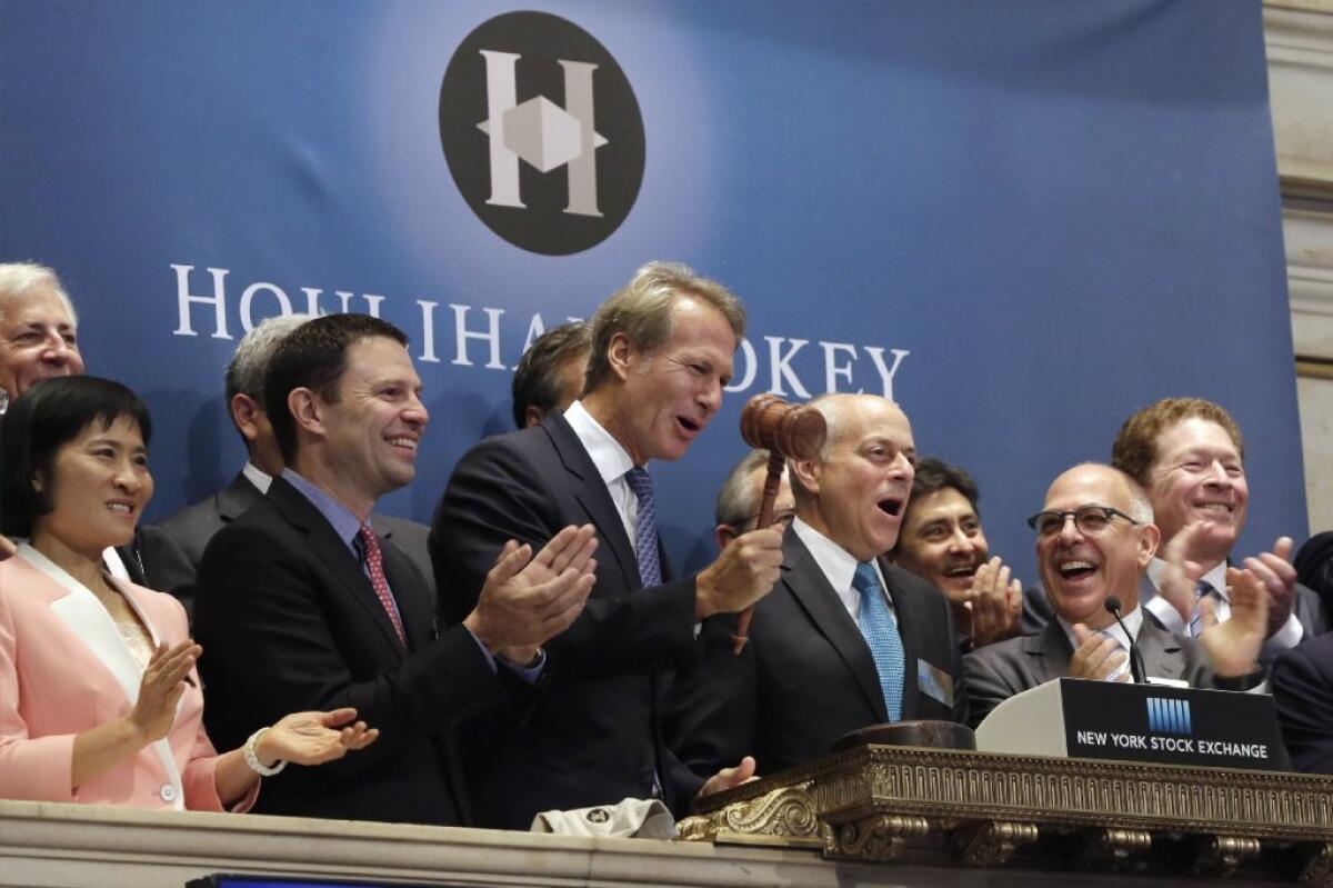 Houlihan Lokey Inc. Chief Executive Scott Beiser, fourth from left, is applauded as he rings the opening bell at the New York Stock Exchange on Aug. 13, 2015, to commemorate his company's IPO.