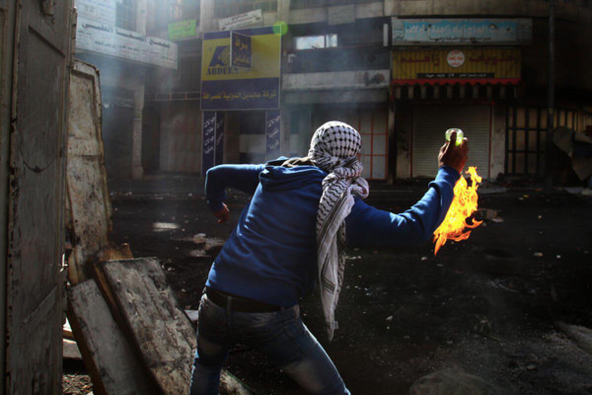 A Palestinian protester throws a Molotov cocktail toward Israeli soldiers during clashes April 3 in the West Bank city of Hebron.