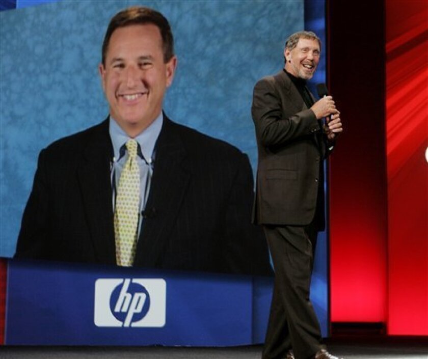 FILE - In this Sept, 24, 2008 file photo, Oracle CEO Larry Ellison, right, and (then) Hewlett Packard CEO Mark Hurd, on screen, smile during the Oracle Open World conference in San Francisco. As co-president at Oracle Corp., ousted Hewlett-Packard Co. CEO Mark Hurd will have to adapt to a new role playing second fiddle to one of Silicon Valley's most domineering bosses _ Larry Ellison. (AP Photo/Paul Sakuma, file)