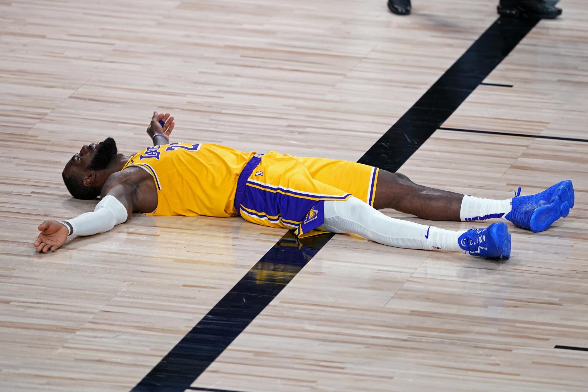 Lakers forward LeBron James lies on the court after committing a foul during the second half.