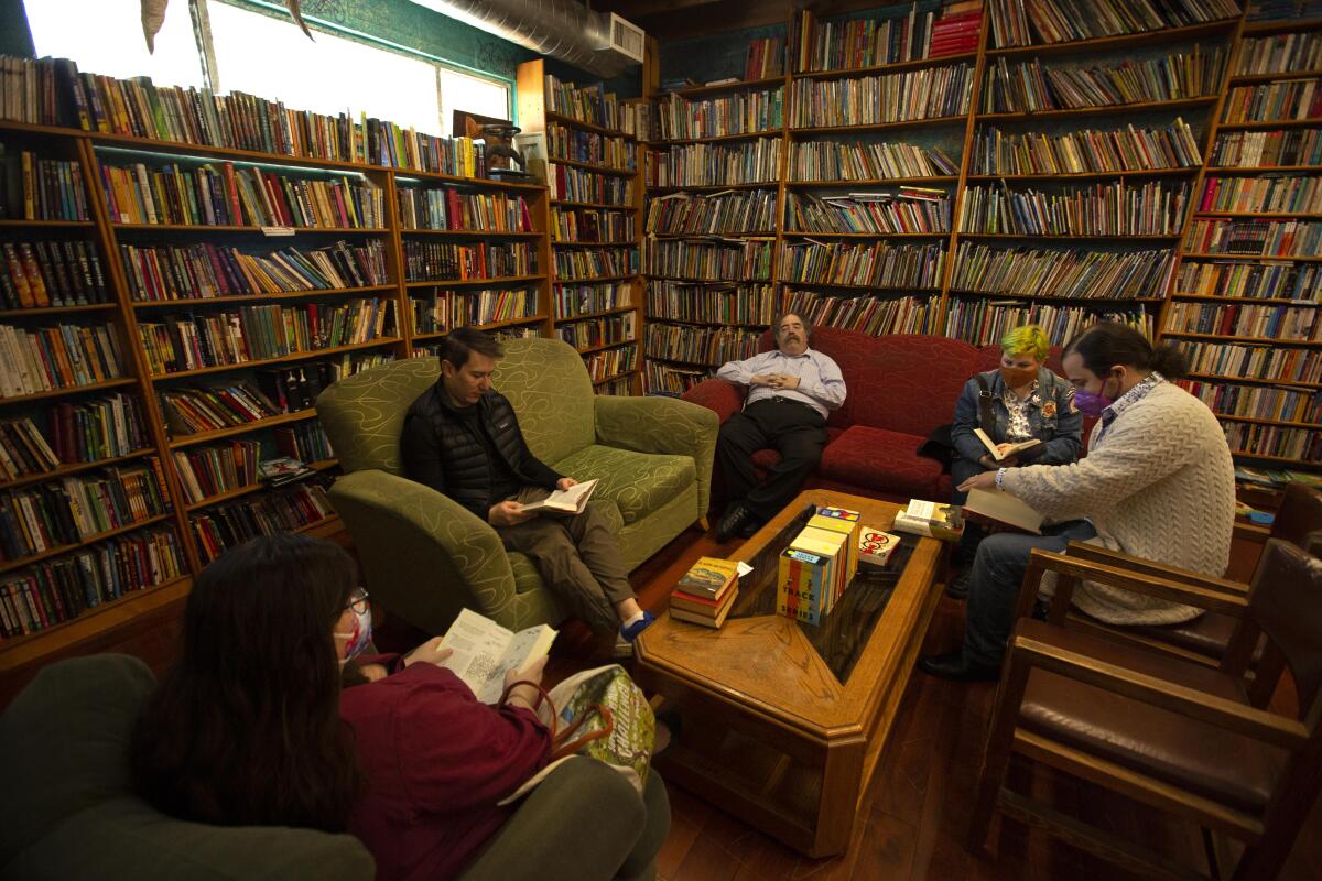 Five customers sit and read inside the Iliad.