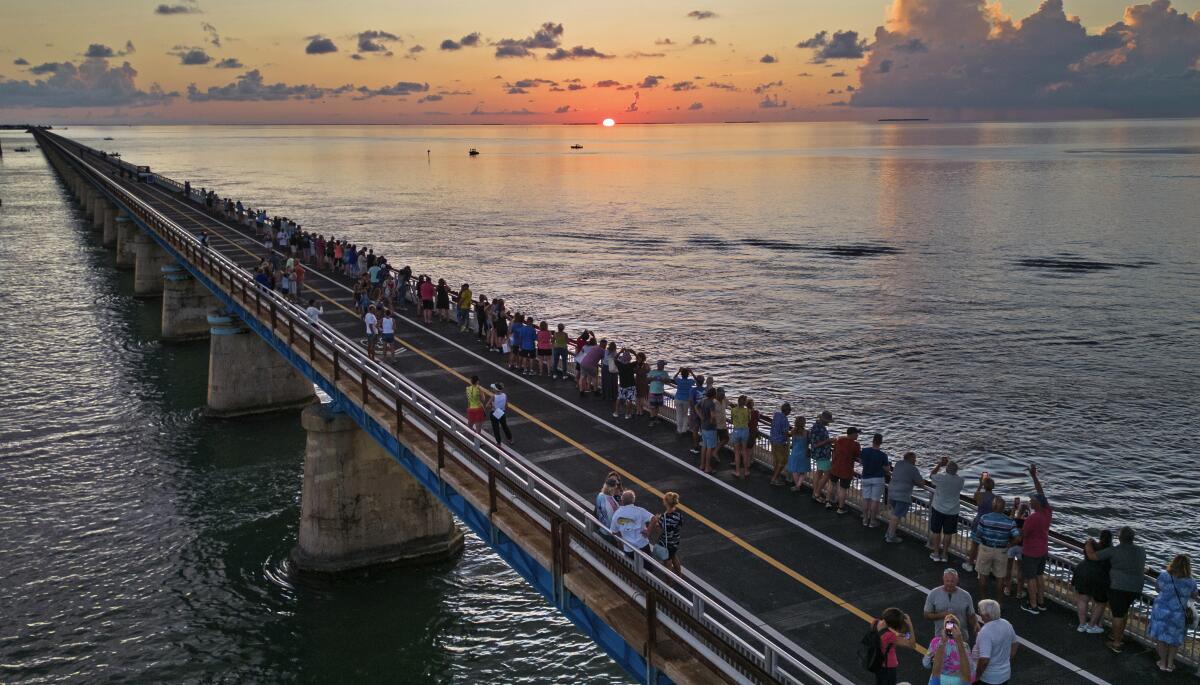 People watch and toast the sunset at a Florida Keys on the restored Old Seven Mile Bridge in Marathon, Fla. 