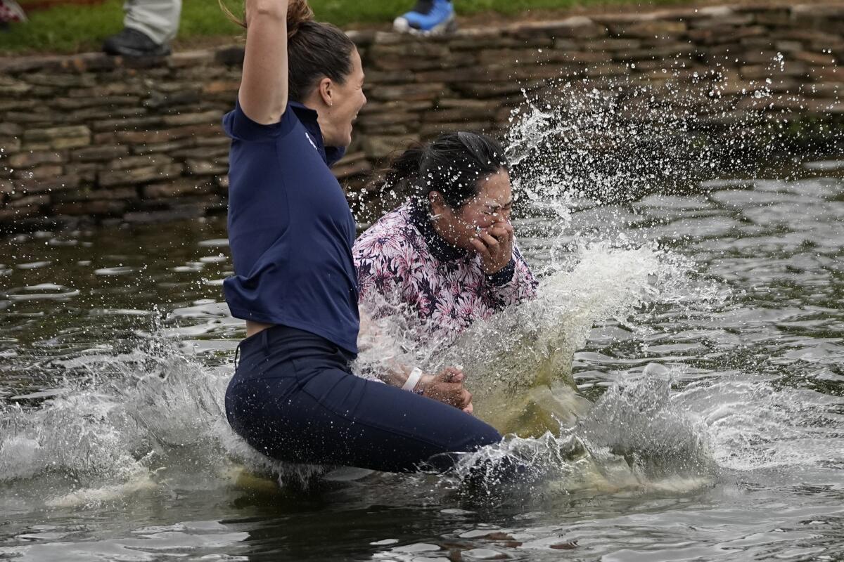 Lilia Vu jumps into the lake on the 18th hole with Anne-Lise Bidou.