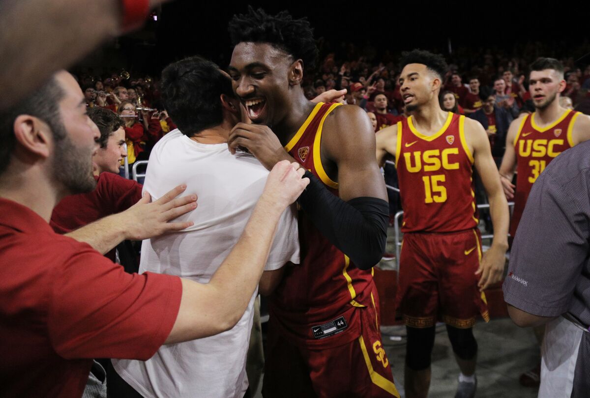 USC's Jonah Mathews, middle, celebrates with fans after making a game-winning three-pointer to beat UCLA on March 7, 2020.