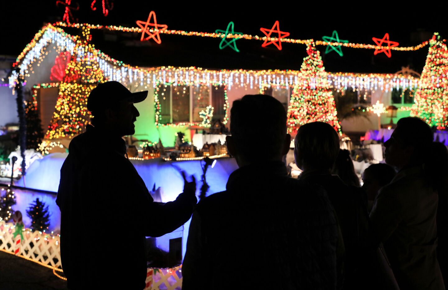 Mack Schreiber, left, speaks to visitors there to see the extensive Christmas decorations at his home on Reche Road in Fallbrook.