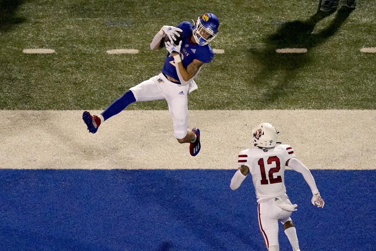 Kansas wide receiver Lawrence Arnold (2) catches a pass over South Dakota defensive back Tre Jackson (12) to score a touchdown during the first half of an NCAA college football game Friday, Sept. 3, 2021, in Lawrence, Kan. (AP Photo/Charlie Riedel)