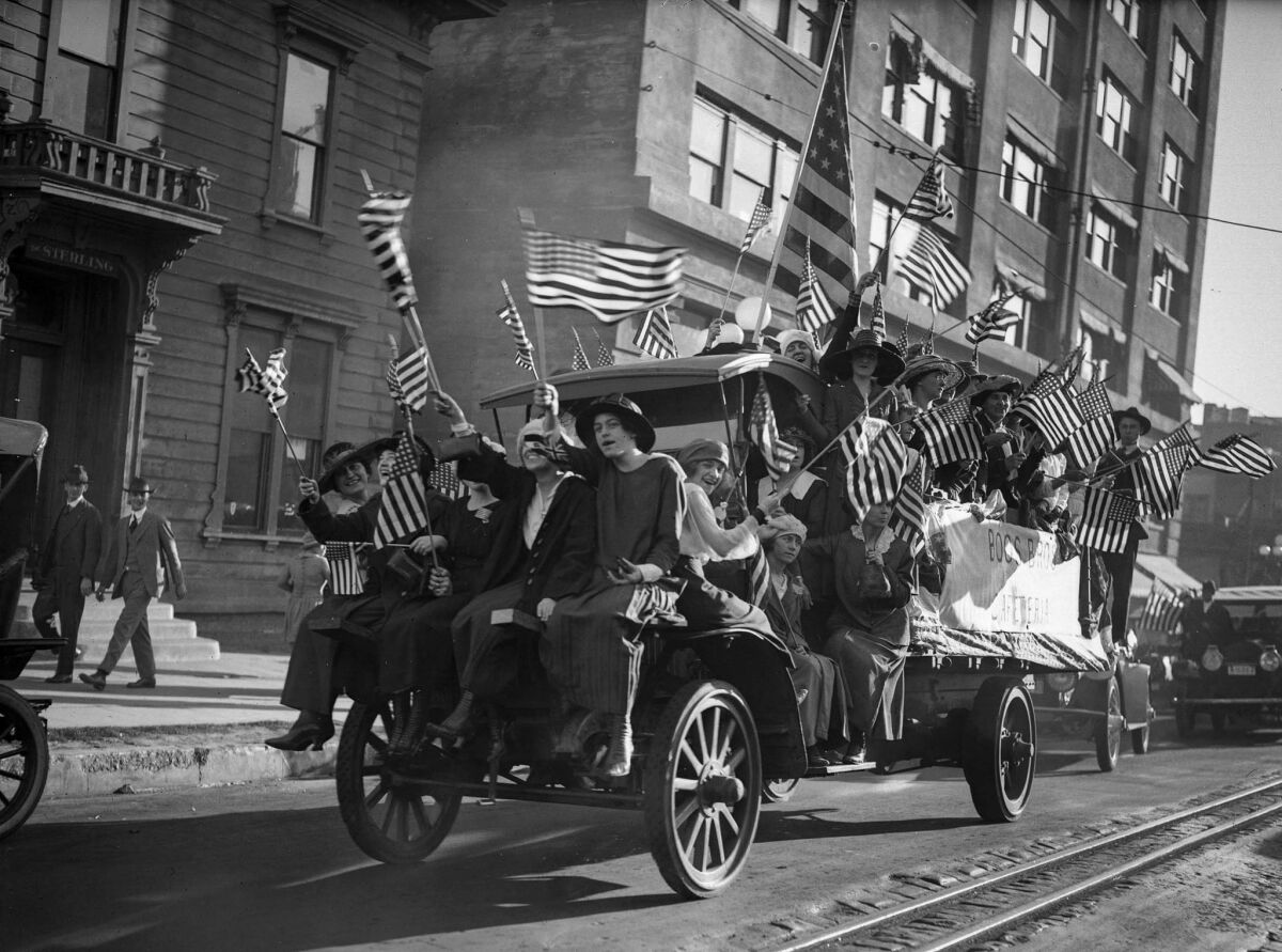 Nov. 11, 1918: Workers from Boos Brothers cafeterias ride through Los Angeles waving flags and singing war songs after Germany's surrender ended World War I.