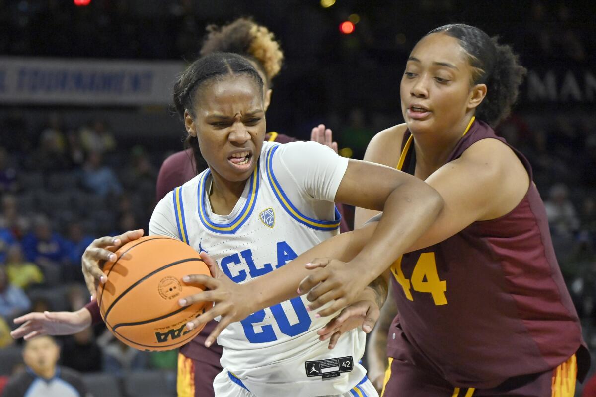 UCLA guard Charisma Osborne handles the as Arizona State guard Isadora Sousa reaches.