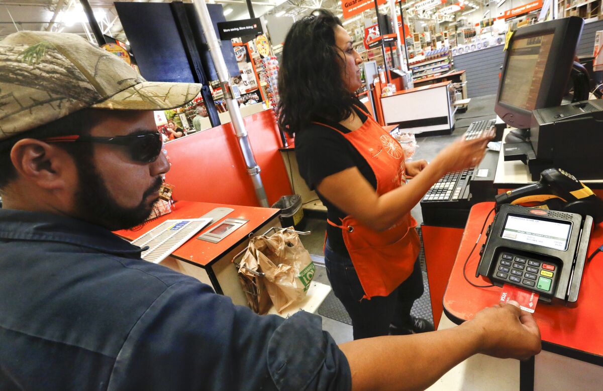 Cashier Janie Thompson waits as Robert Montanez of San Fernando inserts his card, equipped with an EMV chip, into a new reader at a Home Depot in Burbank.