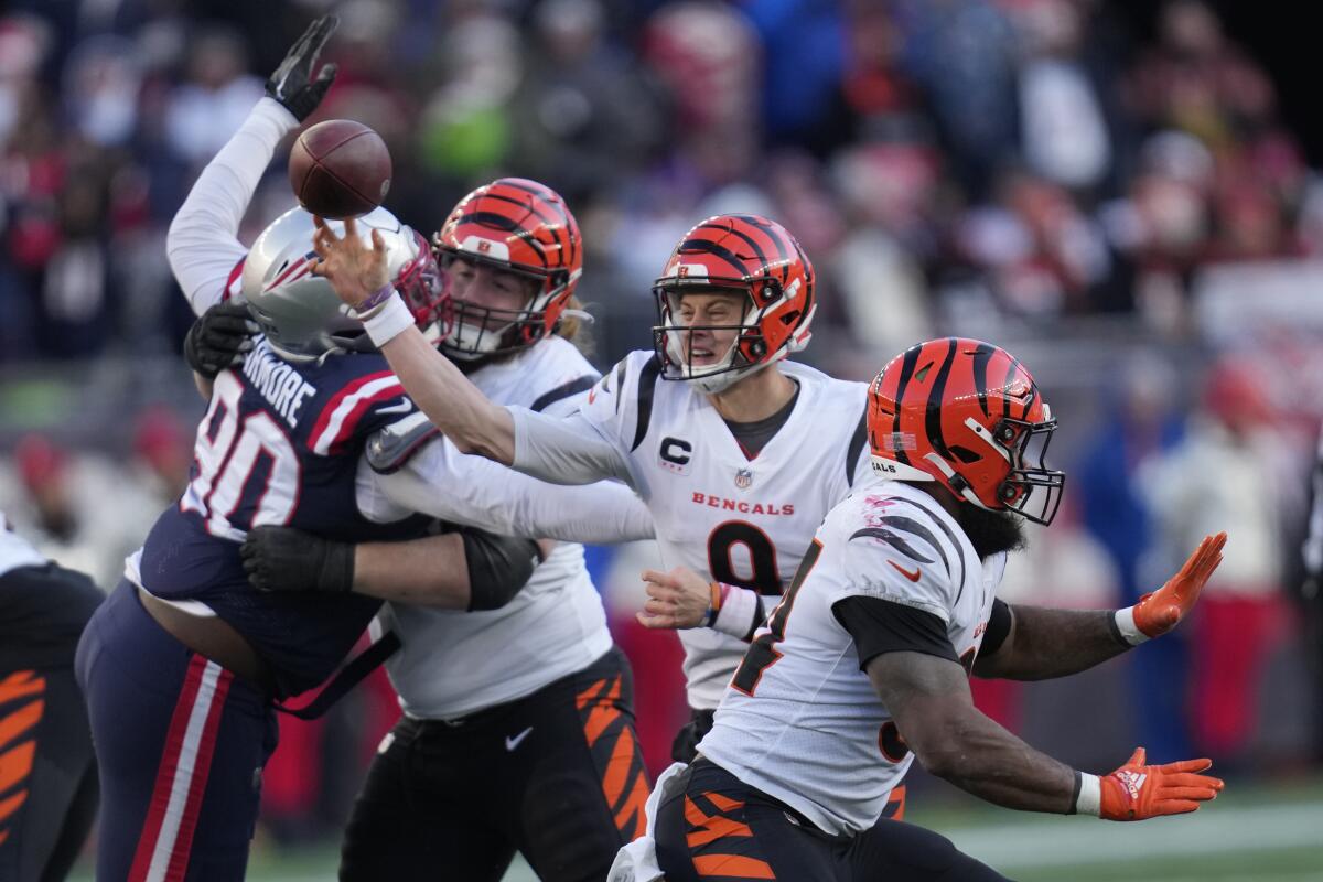 Cincinnati Bengals quarterback Joe Burrow throws under pressure against the New England Patriots.