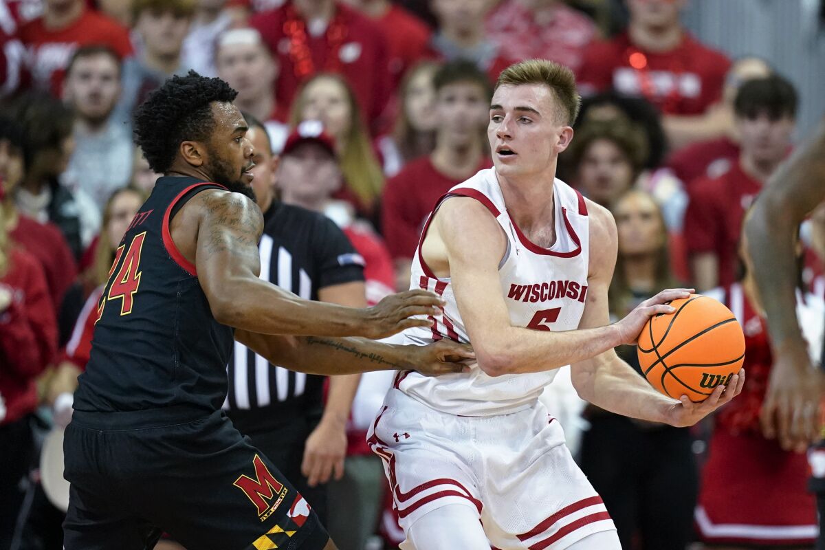 Wisconsin's Tyler Wahl (5) looks to pass the ball as Maryland's Donta Scott (24) defends during the first half of an NCAA college basketball game Tuesday, Dec. 6, 2022, in Madison, Wis. (AP Photo/Andy Manis)