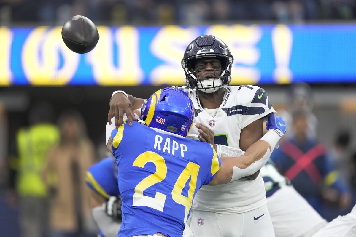 Seattle Seahawks quarterback Geno Smith throws under pressure from Rams safety Taylor Rapp during the first half.