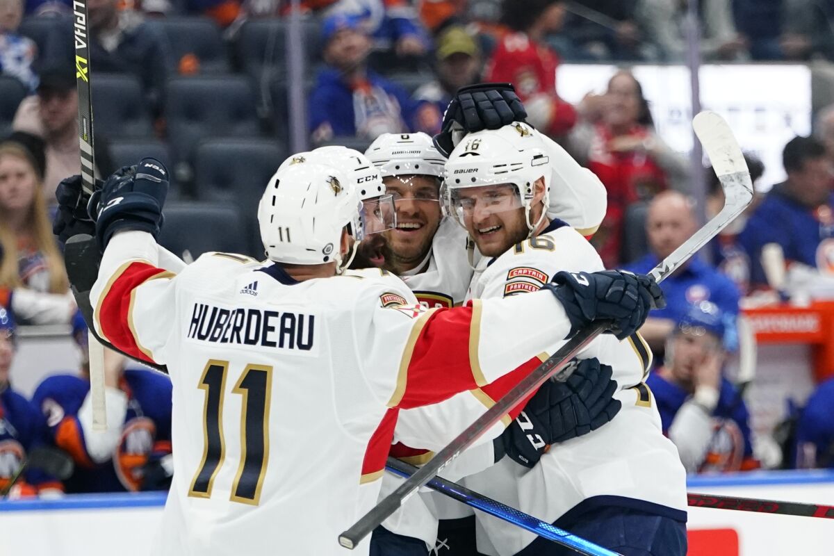 Florida Panthers' Aleksander Barkov, right, celebrates with teammates after scoring a goal during the third period of an NHL hockey game against the New York Islanders Tuesday, April 19, 2022, in Elmont, N.Y. (AP Photo/Frank Franklin II)