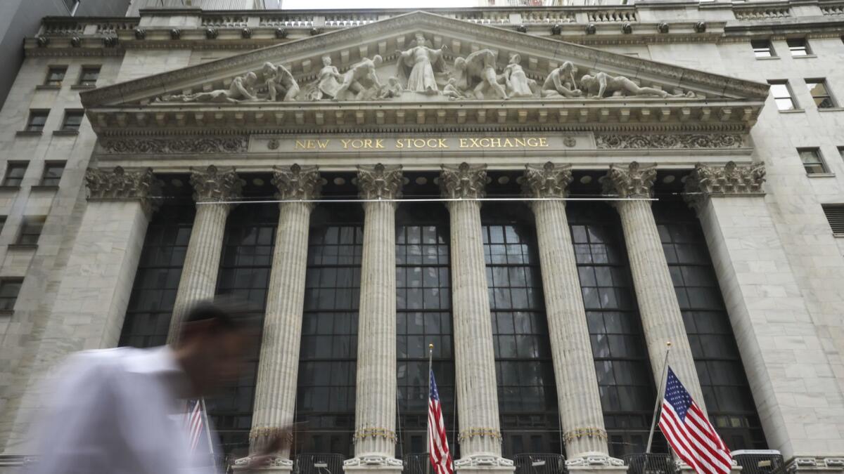 People walk past the New York Stock Exchange.