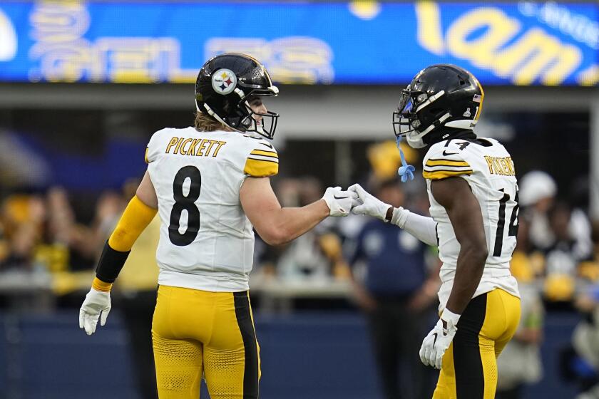 Steelers quarterback Kenny Pickett (left) congratulates  George Pickens after a reception against the Rams.
