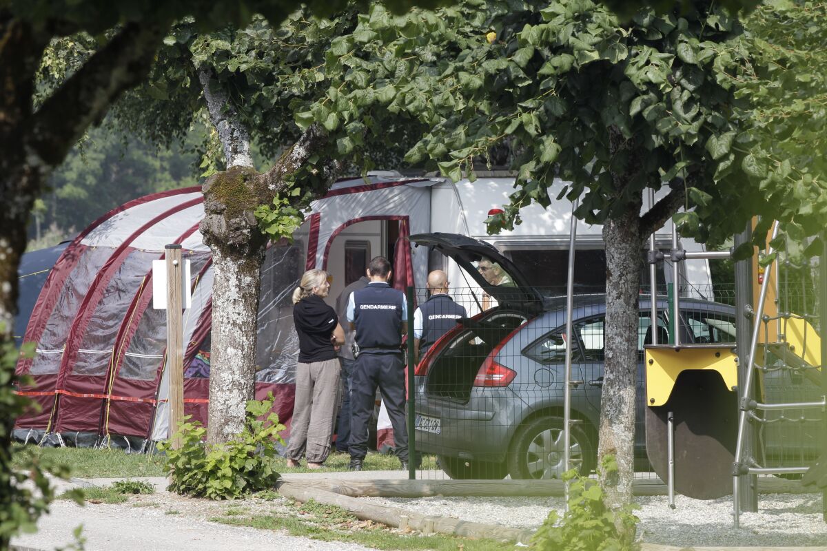FILE - Gendarmes and investigators stand at the camp site where a slain British family were holidaying in Saint Jorioz, near Annecy, on Sept. 6, 2012. A French prosecutor says a suspect in the 2012 slayings of a British-Iraqi family vacationing in the French Alps and a cyclist has been detained. Saad al-Hilli, his wife Ikbal and his mother-in-law Souhaila al-Allaf, were shot dead on a remote mountain road near Annecy in eastern France. A French cyclist Sylvain Mollier was also killed. Al-Hilli's two young daughters survived the attack. A prosecutor said Wednesday that the suspect was detained in the Chambery region. She didn’t give further details on the case because the investigation is ongoing. (AP Photo/Lionel Cironneau, File)