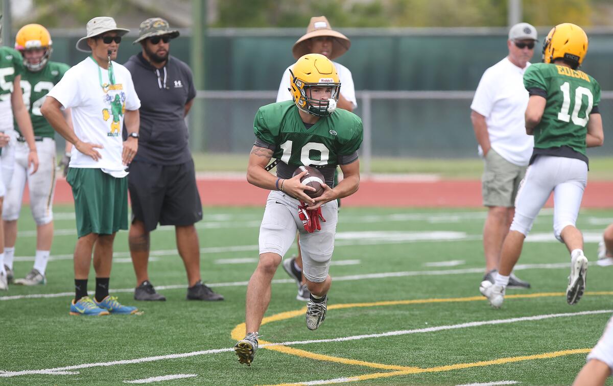 Senior running back Tanner Nelson carries the ball during a drill at Edison's practice on Wednesday.