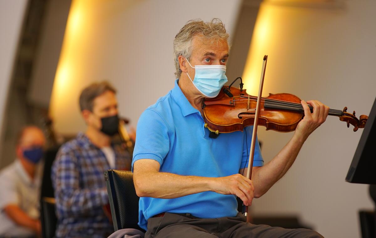 The concertmaster raises his violin. 