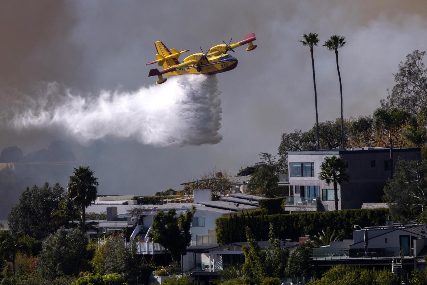 Pacific Palisades, CA - January 07: A Super Scooper drops ocean water on a hillside as the Palisades fire rages on Tuesday, Jan. 7, 2025 in Pacific Palisades, CA. (Brian van der Brug / Los Angeles Times)