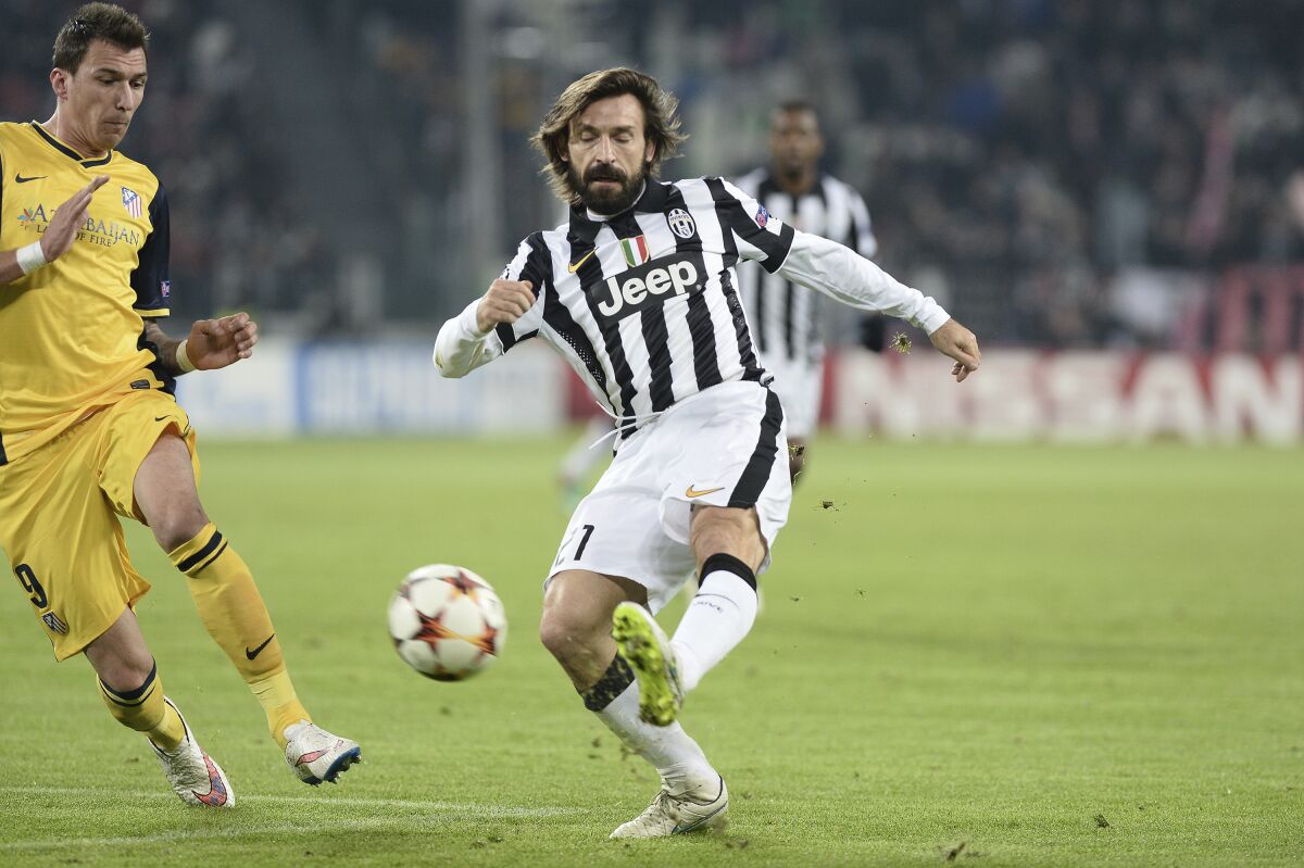 FILE - In this Dec. 9, 2014 file photo, Juventus' Andrea Pirlo, right, challenges the ball with Atletico' Mario Mandzukic during a Champions League, Group A, soccer match between Juventus and Atletico de Madrid at the Juventus stadium in Turin, Italy. New Juventus coach Andrea Pirlo had his coaching qualification rubber-stamped by the Italian soccer federation on Wednesday, Sept. 16, 2020. (AP Photo/Massimo Pinca, file)