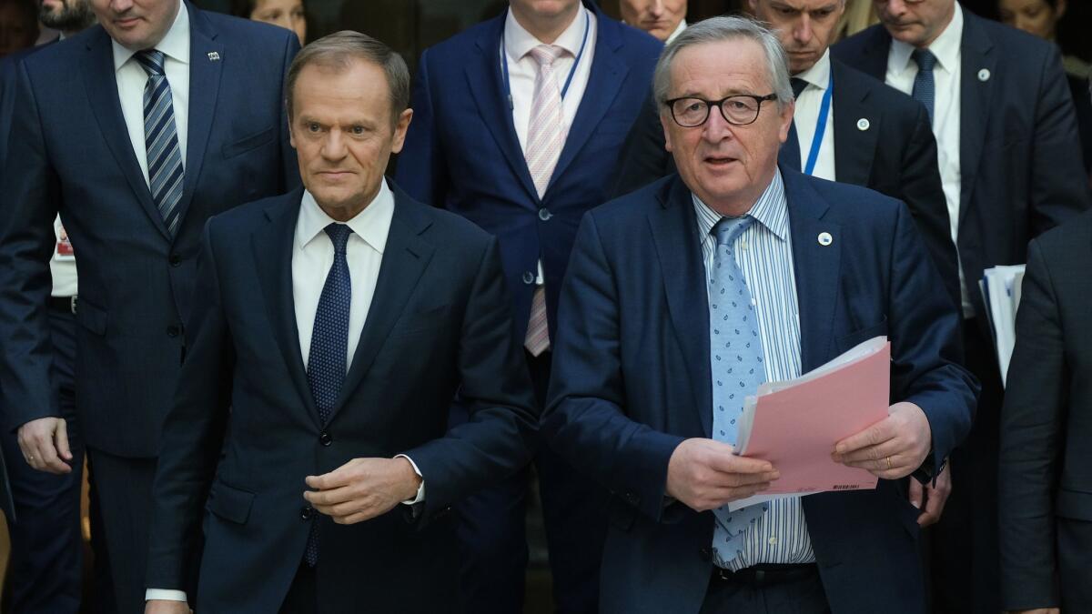 European Council President Donald Tusk, left, and European Commission President Jean-Claude Juncker arrive to speak to the media at the conclusion of a two-day EU summit March 22 in Brussels.