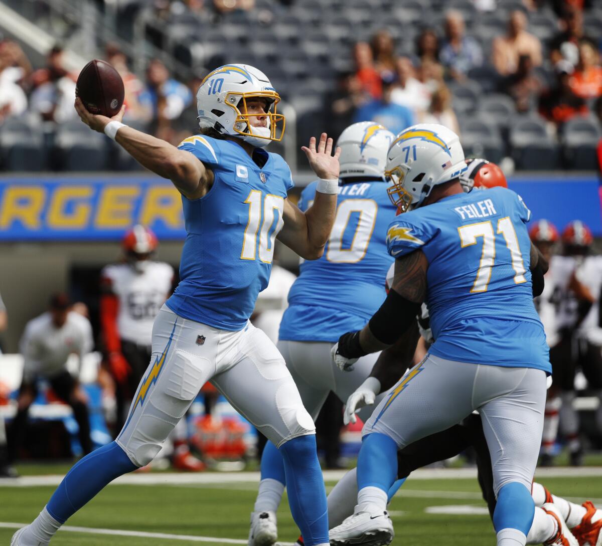 Chargers quarterback Justin Herbert (10) throws as the line pass protects against the Browns.
