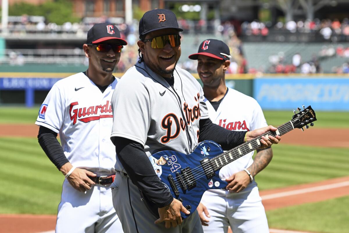 Miguel Cabrera poses after being gifted a custom guitar from the Cleveland Guardians.