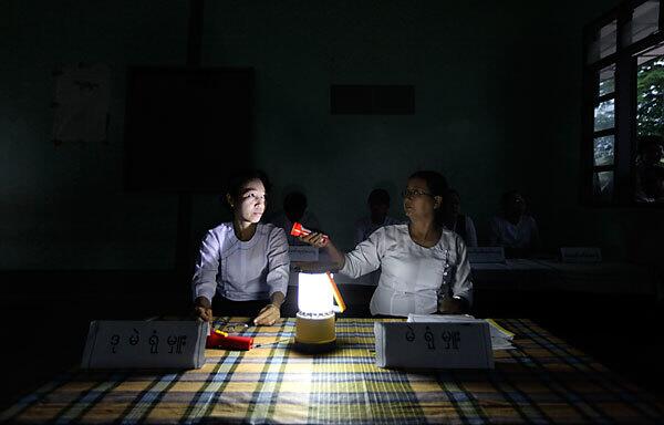 Election officials prepare for voting to begin at a Myanmar polling station
