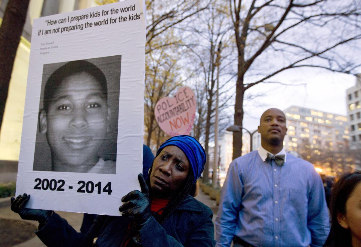 Tomiko Shine holds up a picture of Tamir Rice during a protest in Washington, D.C. 