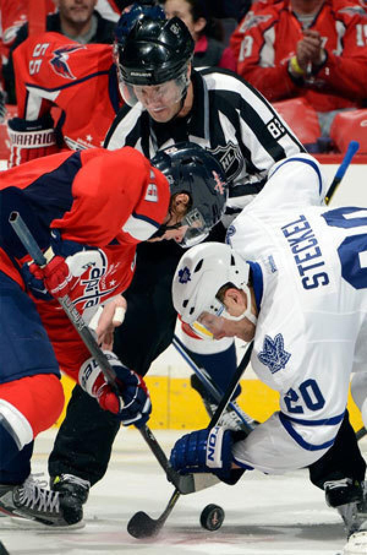 Nicklas Backstrom of the Washington Capitals takes a face-off against David Steckel of the Toronto Maple Leafs.