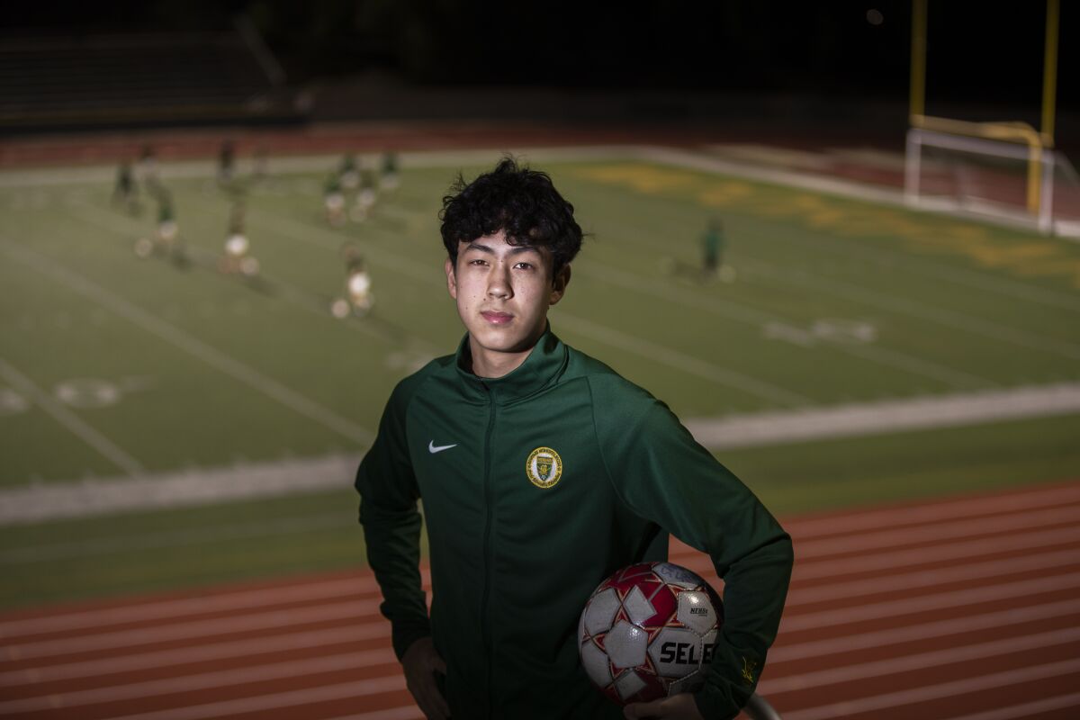 Justin Conyers poses for a photo in the stands above the soccer field at Moorpark High.