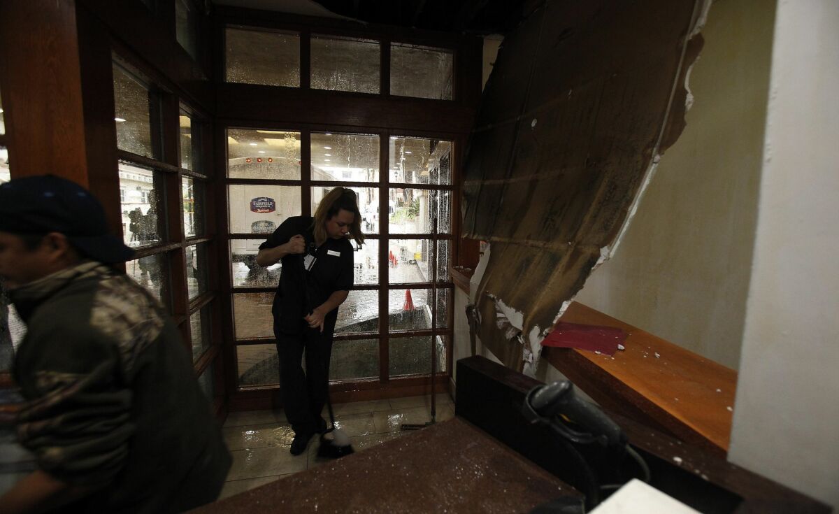 Workers at the Courtyard by Marriottt in Old Town were left with a mess in the lobby where part of the ceiling collapsed from the rain and the below-ground parking area was flooded out, damaging at least three vehicles. — John Gastaldo / San Diego Union-Tribune