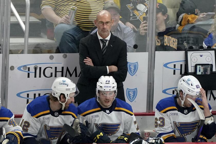 FILE - St. Louis Blues interim head coach Drew Bannister stands behind the bench during the first period of an NHL hockey game against the Pittsburgh Penguins, Saturday, Dec. 30, 2023, in Pittsburgh. The St. Louis Blues have removed the interim tag from Drew Bannister’s title and named him their full-time coach. President of hockey operations and general manager Doug Armstrong announced the move Tuesday, May 7, 2024.(AP Photo/Matt Freed, File)