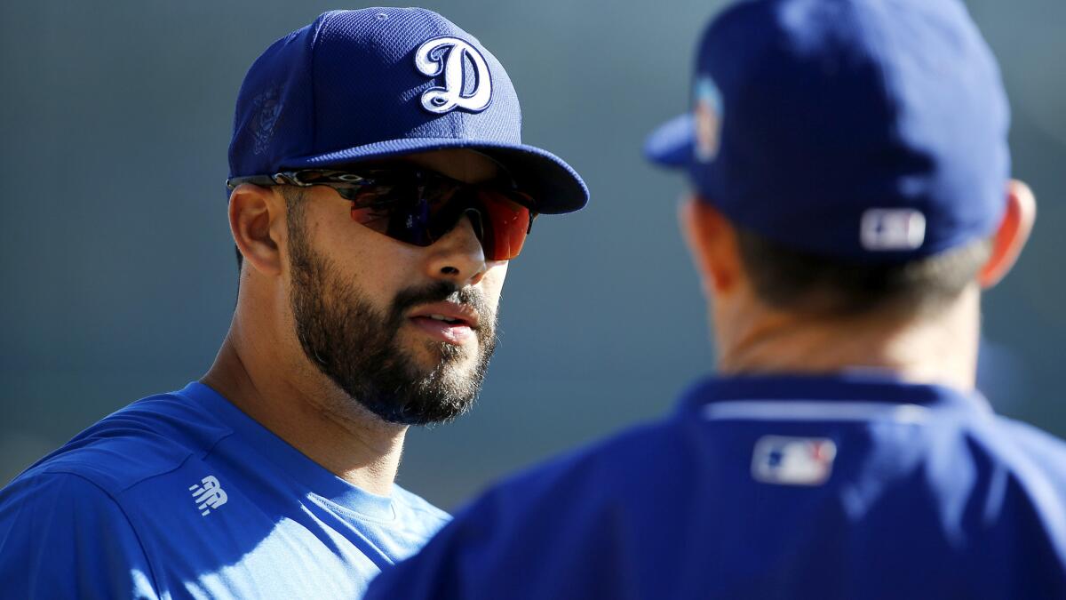 Outfielder Andre Ethier, left, talking with hitting coach Turner Ward during spring training, is back with the Dodgers after sitting out five months because of a broken leg.