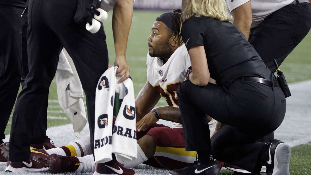 Redskins running back Derrius Guice receives attention on the field after suffering a knee injury in a preseason game.