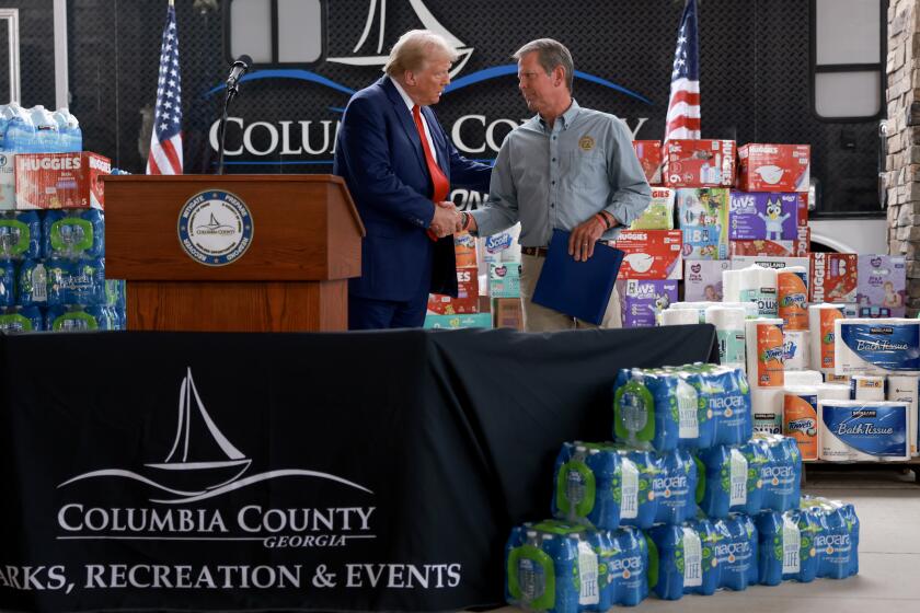 EVANS, GEORGIA - OCTOBER 04: Republican presidential nominee, former U.S. President Donald Trump, and Georgia Governor Brian Kemp shake hands as they visit the area while it recovers from Hurricane Helene on October 04, 2024 in Evans, Georgia. Trump met with local officials, first responders, and residents who have been impacted by the hurricane, which has left over 200 people dead across Florida, Georgia, North Carolina, South Carolina, and Virginia. (Photo by Joe Raedle/Getty Images)