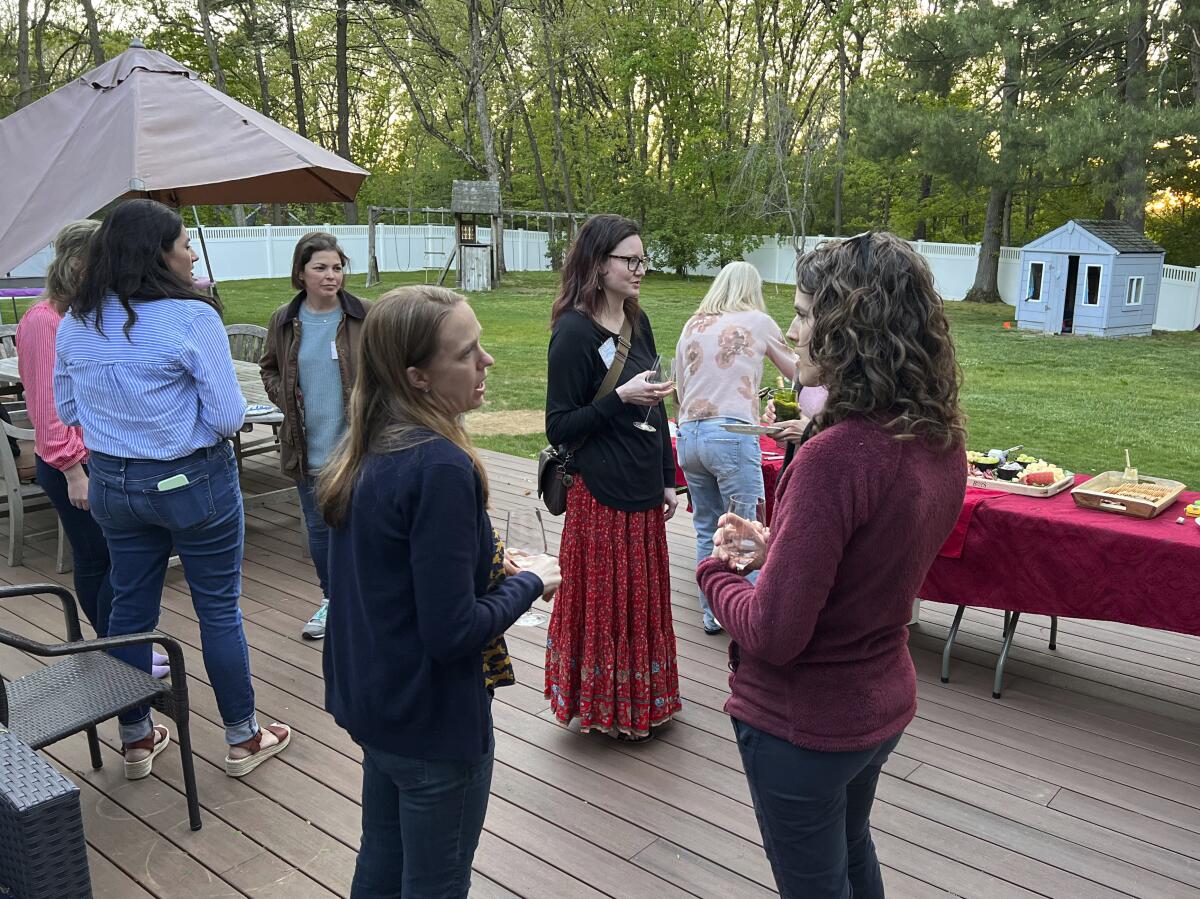 Kindergarten mothers gather for a PTO-sponsored "Moms Night Out" in Newton, Mass., on May 18, 2022. Parent Teacher Organizations have become a place where adults make friends and develop professional skills, all while having some fun. (Tracee M. Herbaugh via AP)