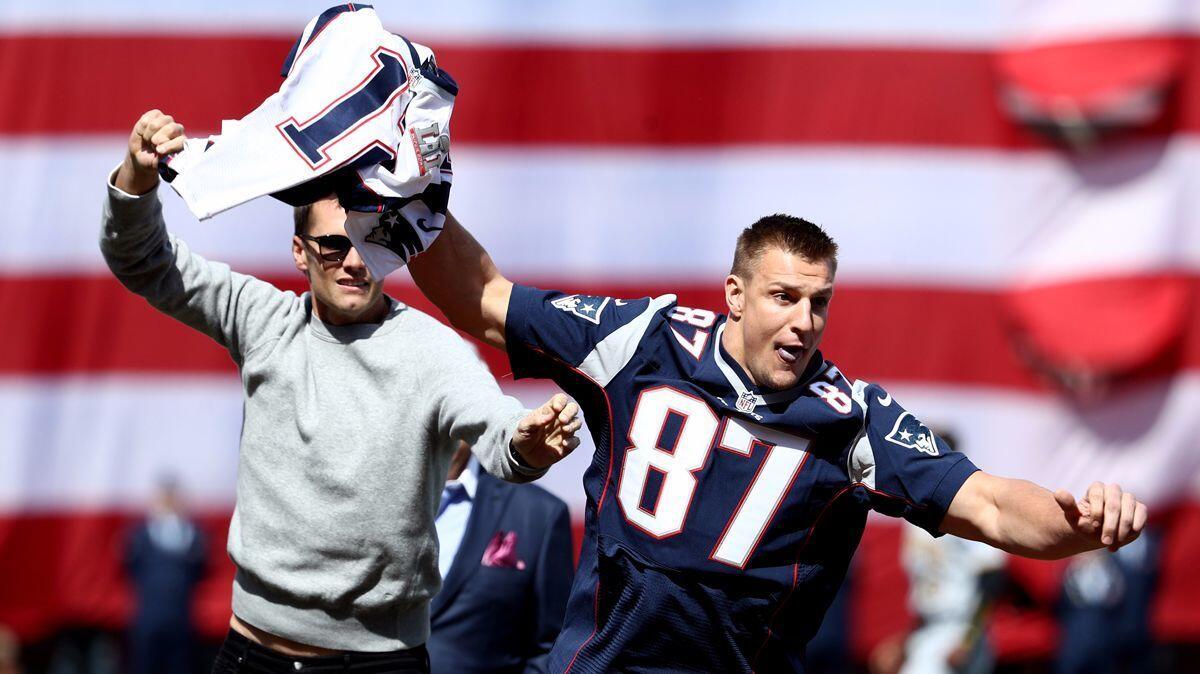 The Patriots' Rob Gronkowski steals Tom Brady's jersey before the opening day game between the Boston Red Sox and the Pittsburgh Pirates on April 3.