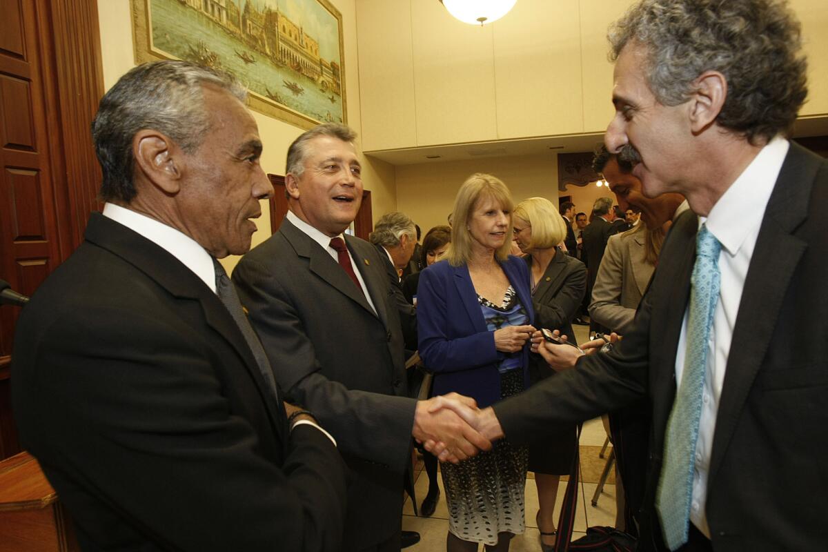 Shaking hands before a debate are City Atty. Carmen Trutanich, center, and Mike Feuer. At left is Jim Bell of the DWP.