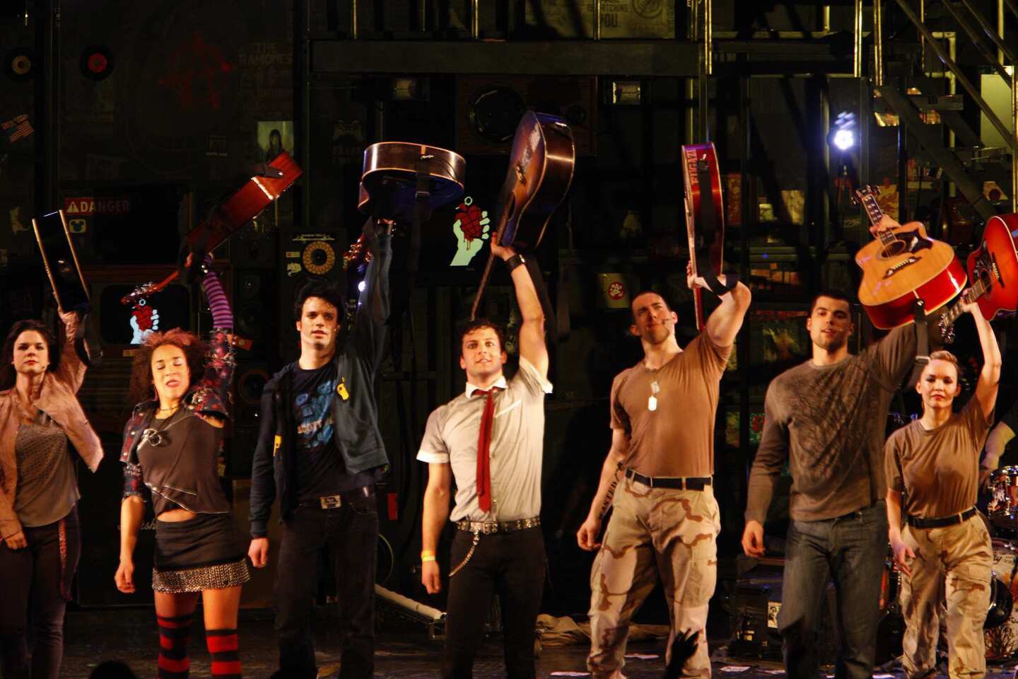 The curtain call is accompanied by the thrumming of many guitars. The tour's three leads are at center: Jake Epstein, in black; Van Hughes in white shirt; and Scott J. Campbell in military fatigues. "American Idiot" is visiting L.A. after its Berkeley debut and a Broadway run.