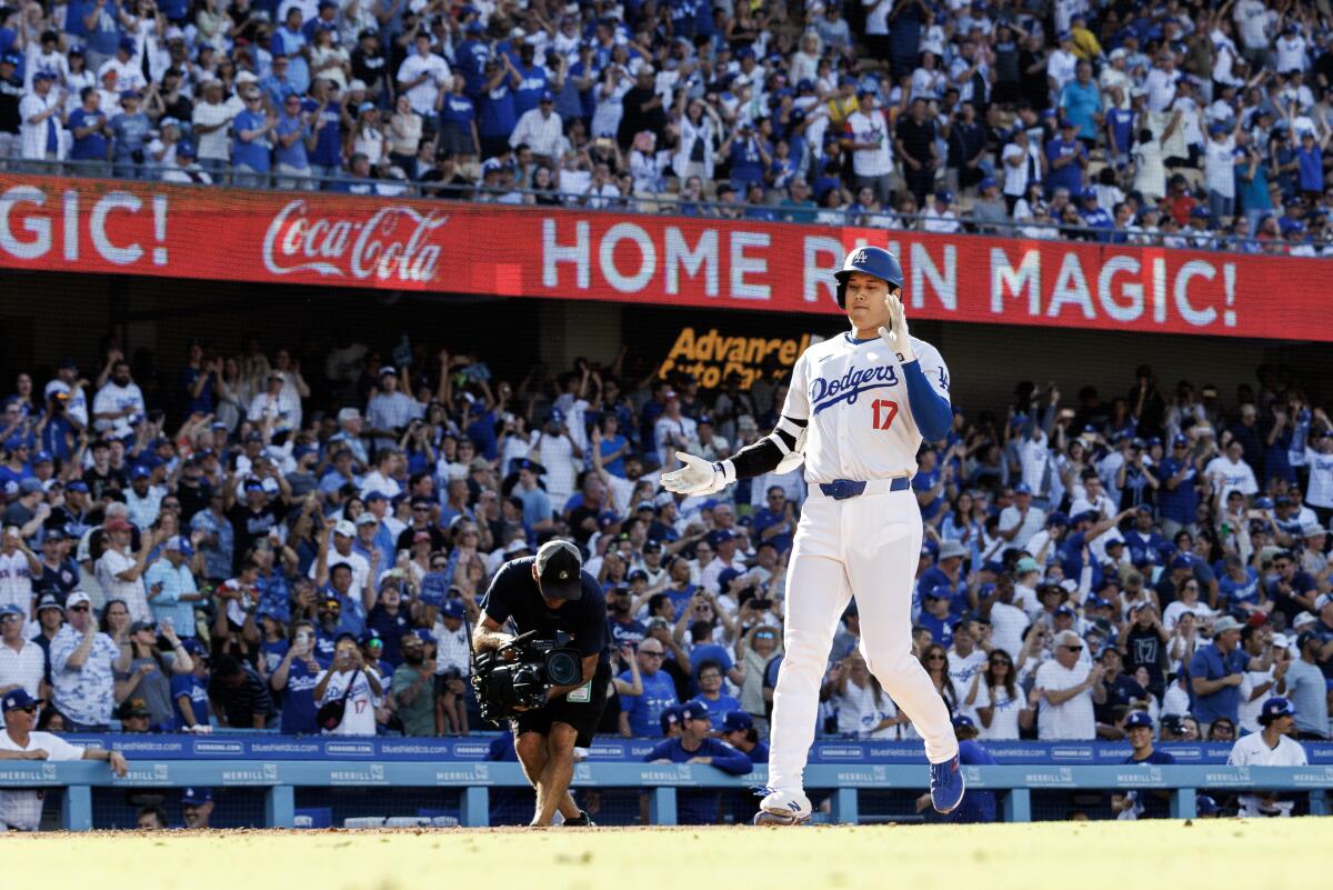 The Dodgers' Shohei Ohtani claps his hands as he reaches home after hitting a monster homer that went 473 feet on July 21.