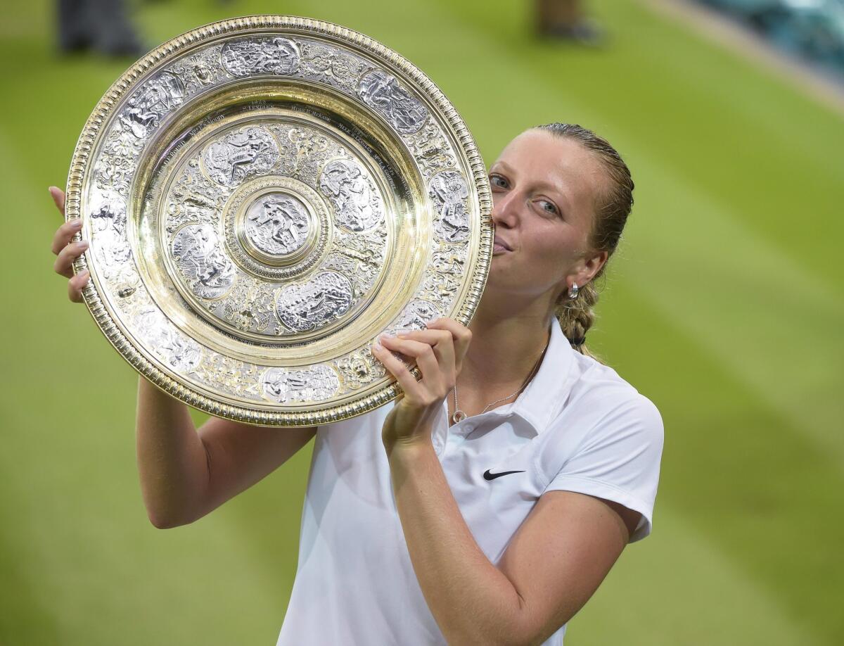 Petra Kvitova holds the championship trophy following her victory over Eugenie Bouchard.