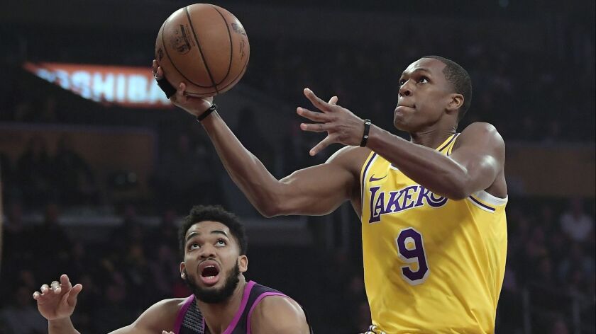 Lakers guard Rajon Rondo, right, shoots as Minnesota Timberwolves center Karl-Anthony Towns defends during the first half.