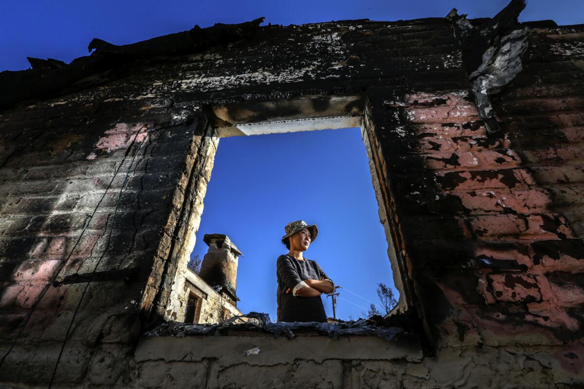 Inja Pak, 46, stands in one of 10 buildings that served as a retreat center. Her husband, Pastor Hyong Pak, died shortly before the Blue Cut fire destroyed the center.