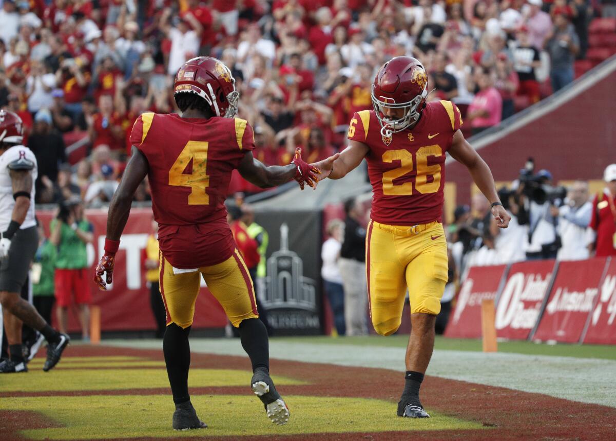 USC running back Travis Dye gets a hand slap from wide receiver Mario Williams after scoring against Washington State.