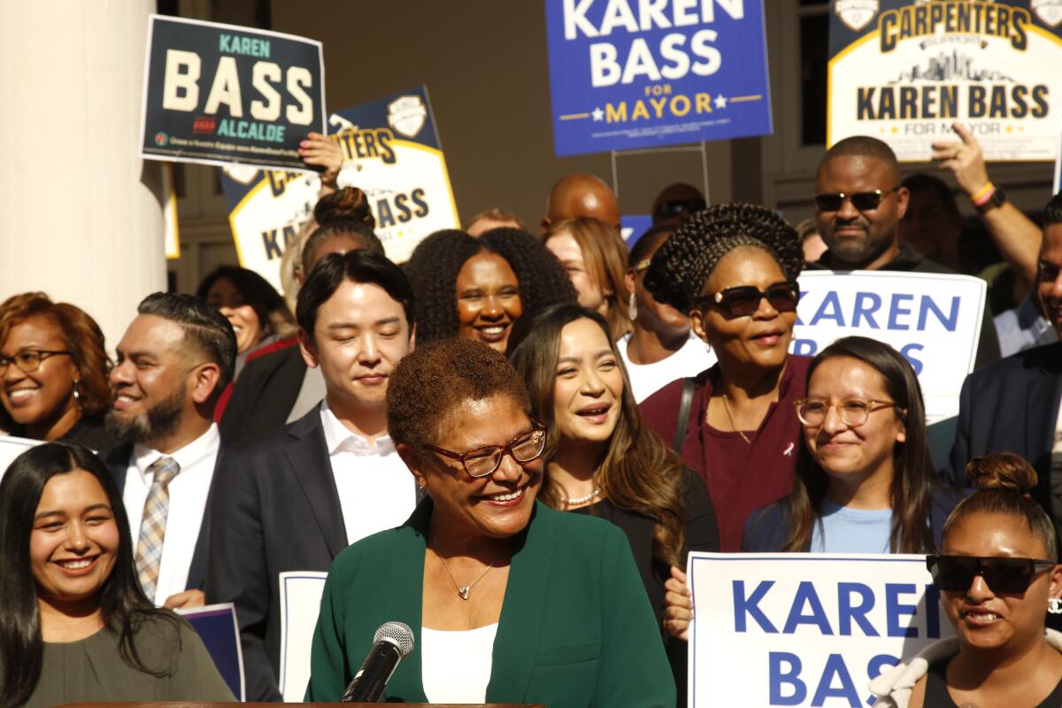Mayor-elect Karen Bass addresses a crowd in front of and behind her