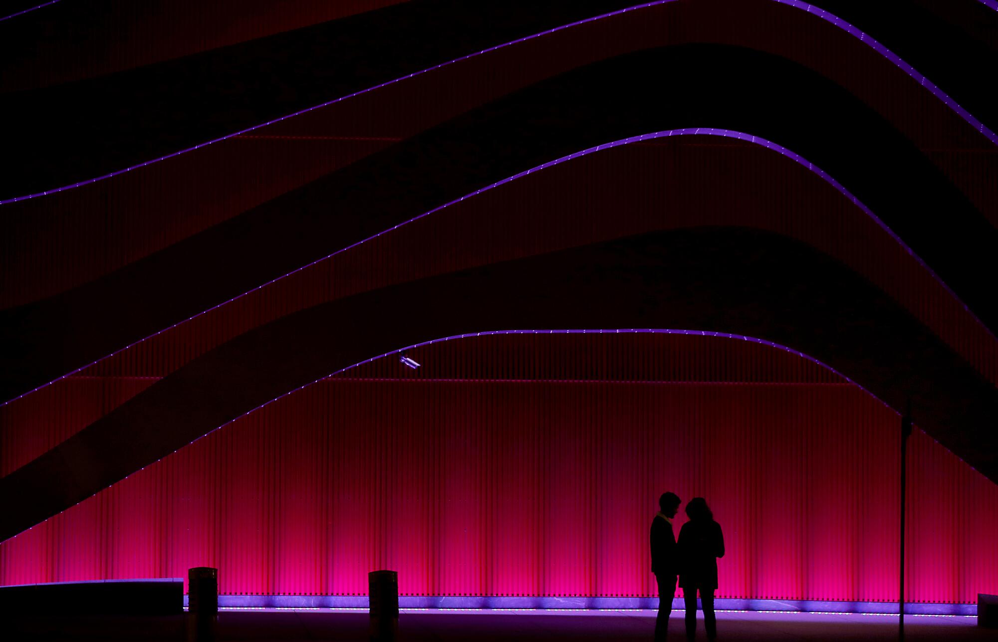 A couple wait for a bus outside the Petersen Automotive Museum in Los Angeles.