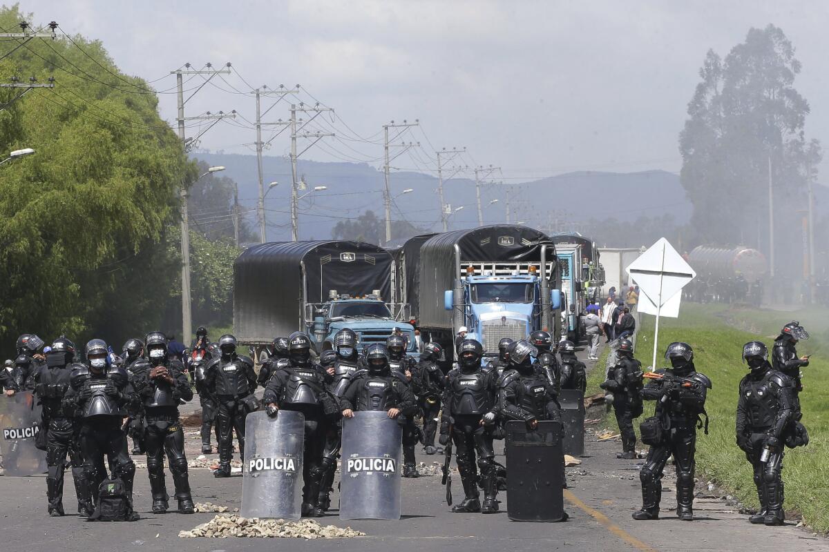 La policía enfrenta a manifestantes antigubernamentales que bloquean una carretera en Gachancipa, Colombia