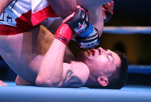 Isaac Gutierrez is in a tough spot as he is pinned by fellow MMA fighter Carlos Garces during Fight Club OC.